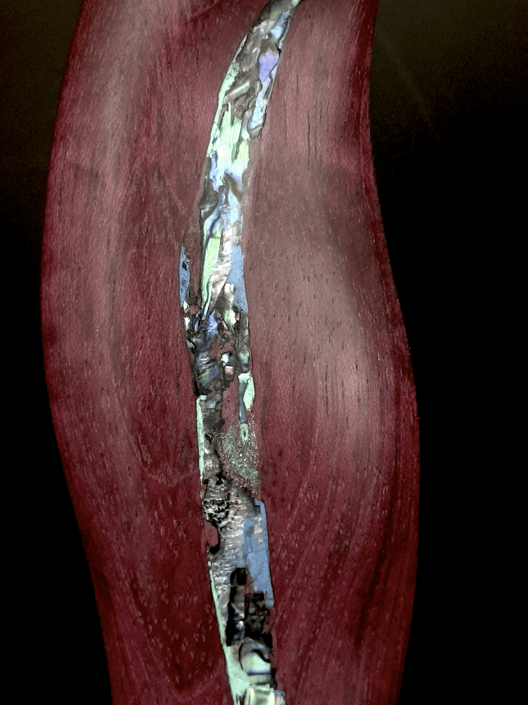 Detail of abalone shell inlay on purple heart wood"