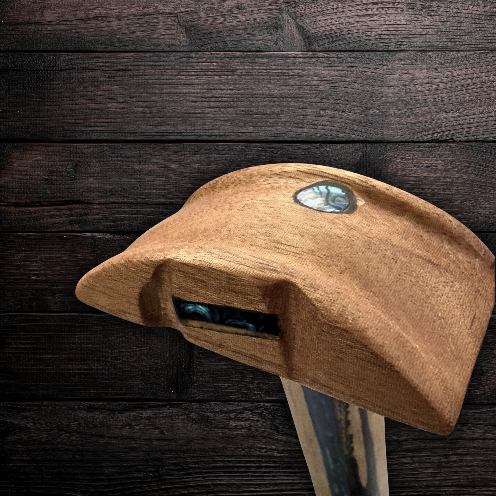 Close-up of abalone shell tribal design on rosewood stand