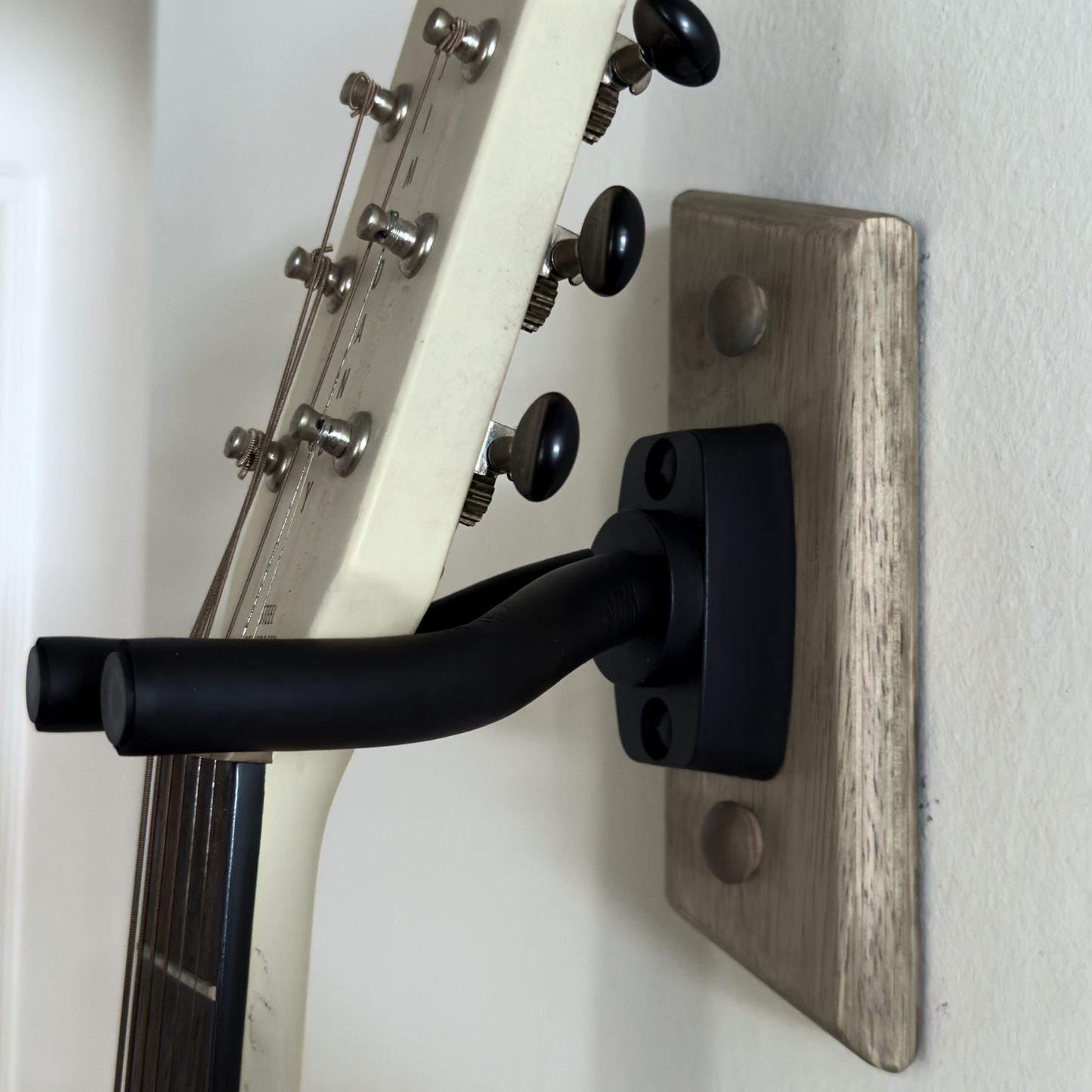 Close-up of adjustable pivoting arms on handmade guitar wall hanger