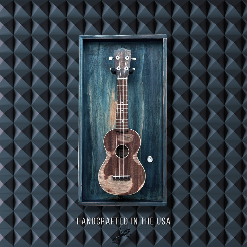 Framed ukulele with 'Handcrafted in the USA' text on a textured black background