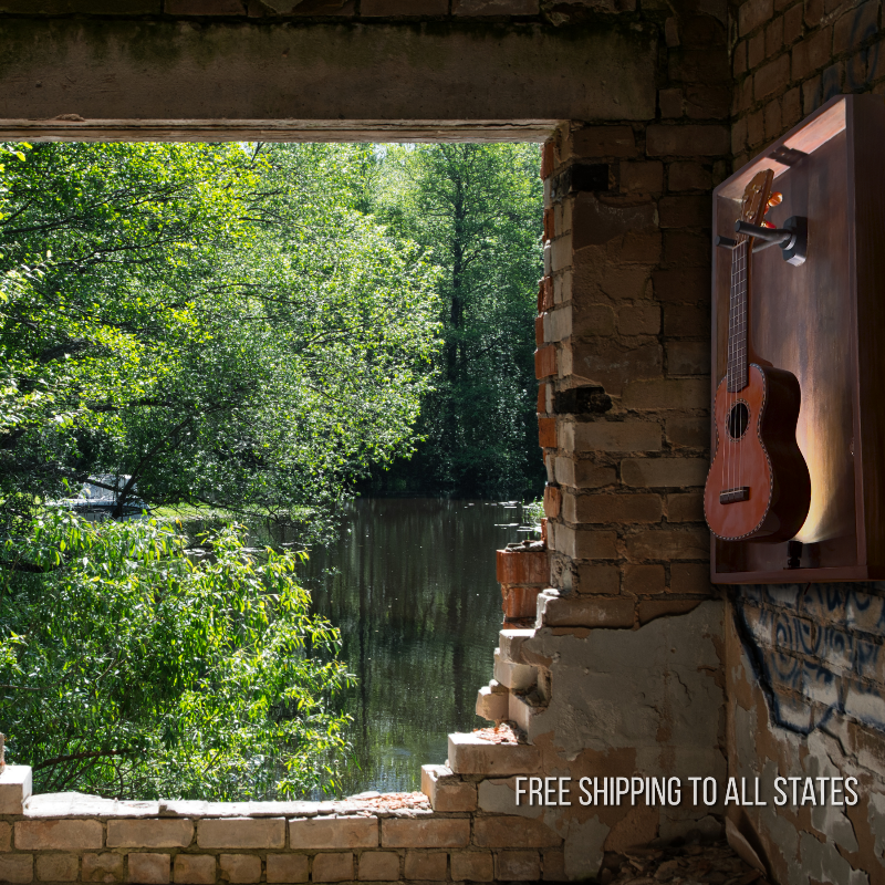 View of a lake through a brick archway with the Uke Barn displaying an Ukulele on the wall, featuring free shipping text.